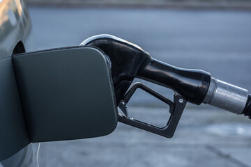 gasoline pump nosel in car gas tank at gas station