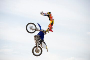Unknown rider jumping with motocross motorcycle in freestyle mode