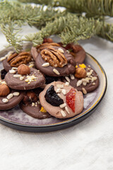 French sweets with walnuts and berries. Chocolate mediants on plate. Home pastry chef. Sweets for the holiday