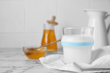 Delicious milk and honey on white marble table. Space for text