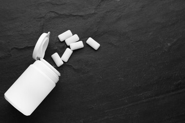 Jar with chewing gums on black table, flat lay. Space for text