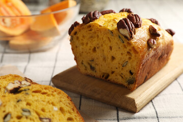 Delicious pumpkin bread with pecan nuts on tablecloth, closeup