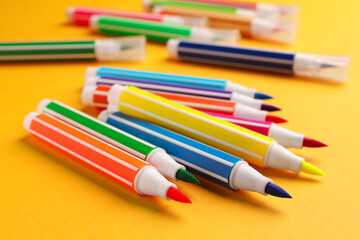 Fototapeta premium Many bright markers on yellow background, closeup