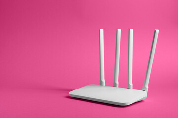 New white Wi-Fi router on pink background. Space for text