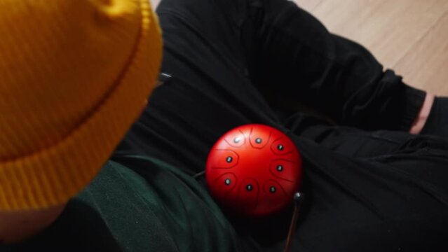 Man playing red tank HAPI drum with sticks. High quality 4k footage