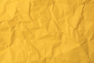 Sheet of crumpled orange paper as background, top view