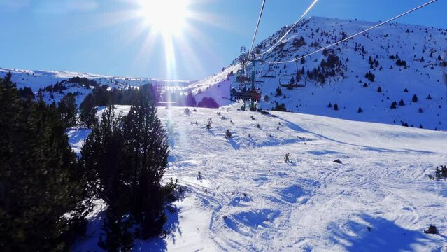 Slowmotion shot ski resort in the Pyrenees with skiers climbed on the ski lift to climb the mountain, Grandvalira, Andorra.