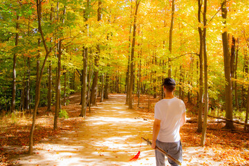 A man walking in a forest and grass field in Canada.