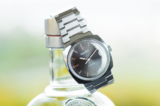 Vintage men's steel dress watch Poljot. Anthracite dial. Made in USSR. Watch laying on the bottle. Light blurry background. Copy space for the text. Switzerland, Bern - OCTOBER 5, 2020.