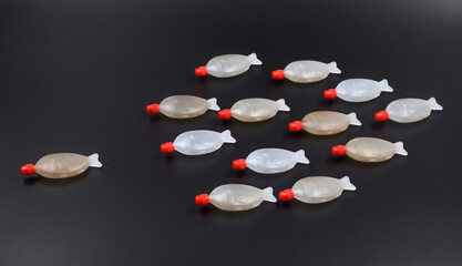 Plastic fish shoal. Plastic fish container from soy sauce fo sushi on black background....