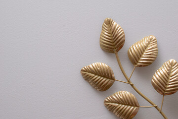 golden metal leaves on a white wall