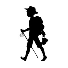 Silhouette: Ein Junge oder Pilger geht barfuß mit dem Rucksack auf dem Rücken, Hut auf und den Schuhen in der Hand mit einem Wanderstab und einer Jakobsmuschel auf Wanderung oder den Pilgerweg.