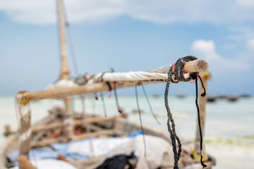 Wooden boat anchored on the African shore Zanzibar in clear ocean water