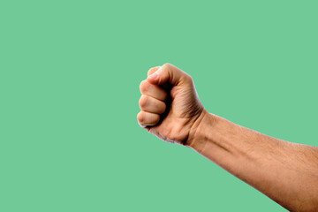 Clenched man's fist on a green background. 