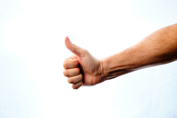 Man's hand with thumbs up giving an ok, ok sign.