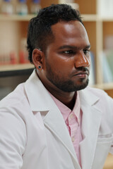 Portrait of pensive serious scientist in white labcoat