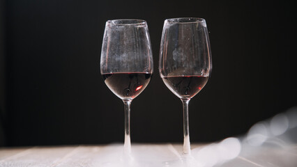 Set of hands holding red wine glass isolated on black background.