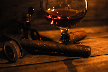 Rum drink with tobacco cigar, handmade on rustic wooden table with coppery colors and low lighting
