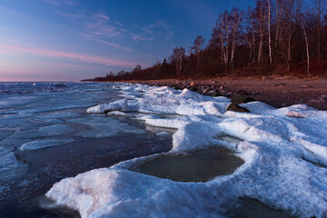 Wonderfully beautiful sunset by the sea in winter with ice