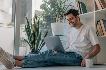 young man at home with computer and cup of coffee