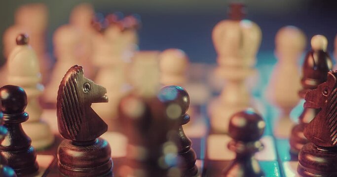 Chess game. Close-up view hand makes strategic move with figure on board. Smart thought of grandmaster, victory. Focusing on king. Checkmate. Sports concentration. Attack and Logical Step Forward.