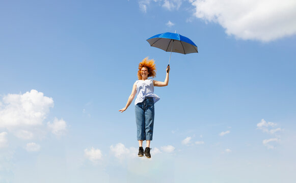 Young woman hopping with an umbrella