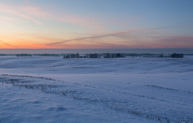 sunny, snowy winter day in the countryside at sunset