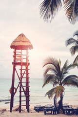 Retro toned picture of an empty tropical beach with lifeguard tower, travel concept.