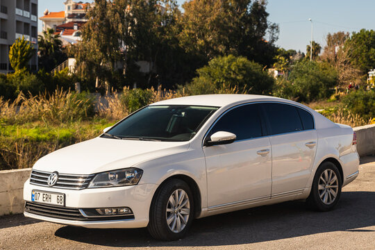Side, Turkey - january 23 , 2023 :  white  Volkswagen Jetta is parked  on the street on a warm summer day against the backdrop of a buildung,  garden