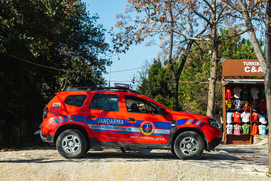 Side, Turkey -January 23, 2023:   red  Dacia Daster   Jandarma   is parked  on the street on a warm summer day against the backdrop of a buildung, trees