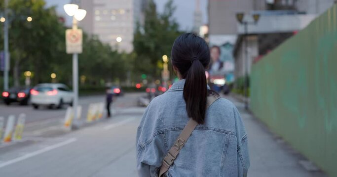 Woman walk in the street in the evening
