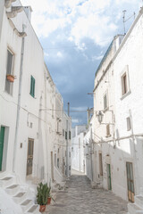Fototapeta na wymiar Street and clouds in Ostuni white city (Città Bianca), Puglia, Italy
