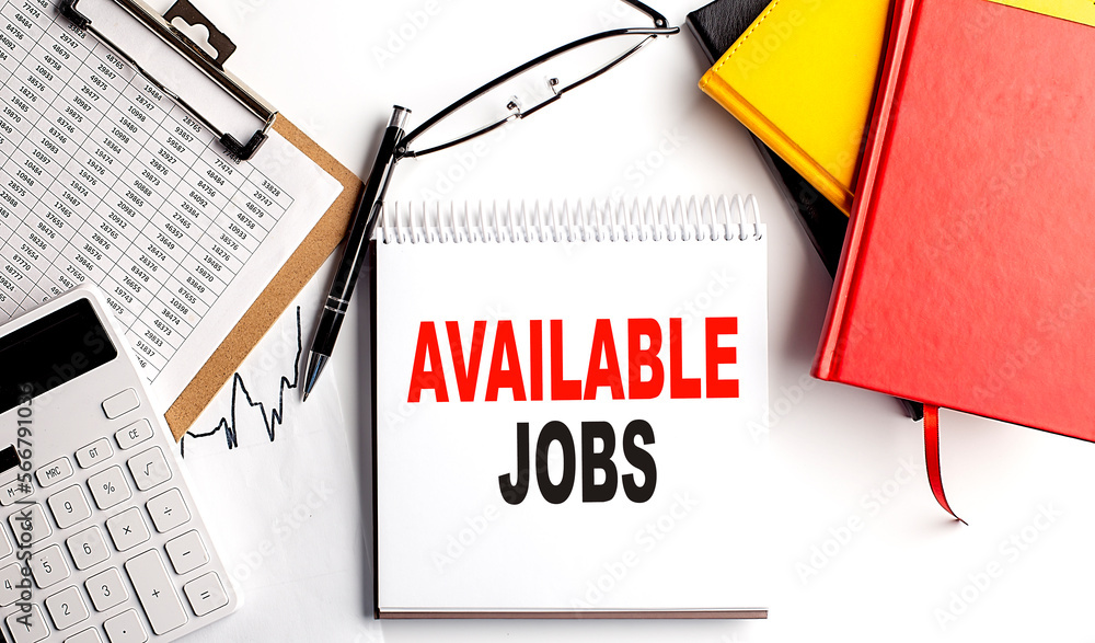 Poster available jobs text on notebook with clipboard and calculator on white background