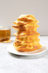 Sakotis ,sekacz, baumkuchen is traditional spit cake in lithuanian, polish, german, belarusian cuisine made of butter, eggs, flour, sugar cooked on rotating spit over open fire. Cup of tea. Vertical