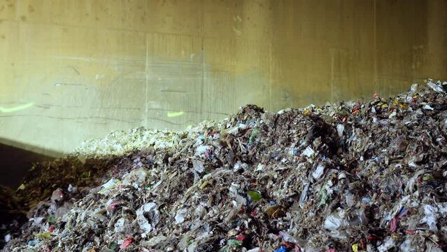 Heap of organic waste at compost recycling station. Bad quality organic waste polluted with plastic garbage at city waste management plant. Waste with organic and plastic trash. 4k ProRes footage