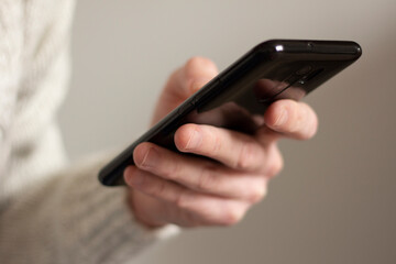 Smartphone in the hand of a man. Looks at the display. Internet search, message exchange. Video motion closeup