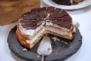 Eine angeschnittene Schoko Creme Torte bei der schon Stücke fehlen.
