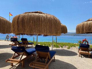 sunbeds, umbrellas and green lawns with sea view. Relaxation, sunbathing and rest area , selective focus blur, Antalya, Ölüdeniz, lykia, 2022