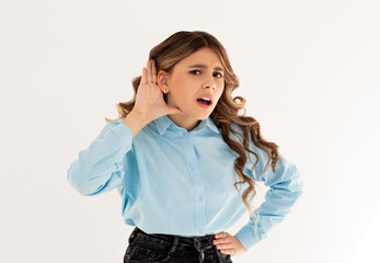 Portrait of a young girl with hand on ear. What did you say? Isolated on white background