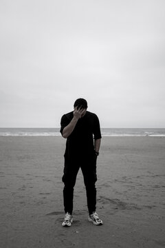 Depressed, sad man dressed in black. Loneliness concept. Black and white photo. Copy paste, text space.