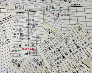Old library card collection with rubber stamped dates from the late 20th century to the early 21st...