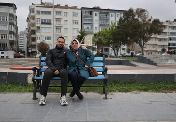 Obraz premium The mother and her son are sitting on the bench.