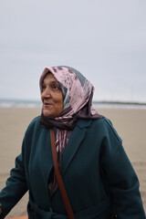 Old, retired woman is talking. She wears hijab.