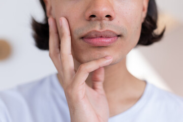 Biracial man holding his face