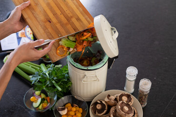 Midsection of biracial man cleaning waste in kitchen