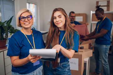 Portrait of a two woman volunteer working in a charity donation center