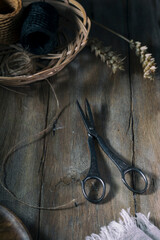 Old scissors and a basket on a rustic table