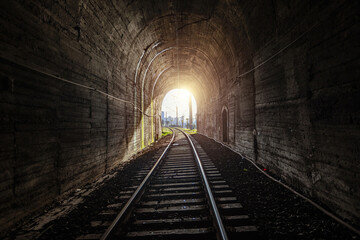 Naklejka premium Sunset light at the end of railroad tunnel