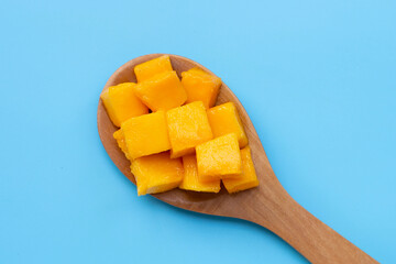 Tropical fruit, Mango cube slices on blue background.