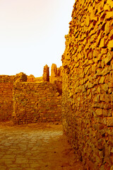 Old ruines in kenadsa ksar built with dry stones. Orange colored and enlightened with golden hour...